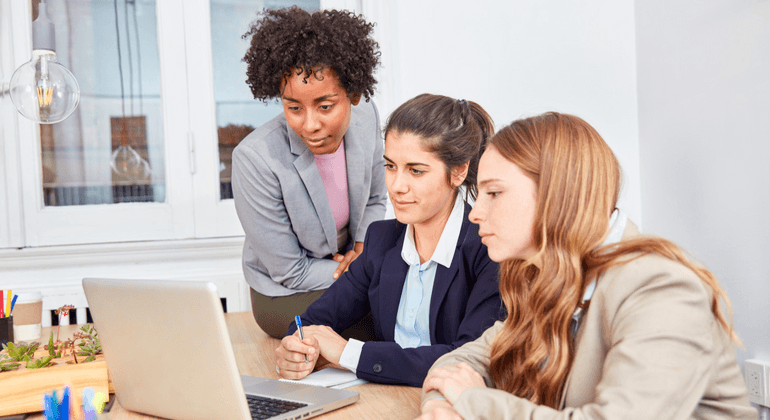 Three women learning about cyber security training on a laptop
