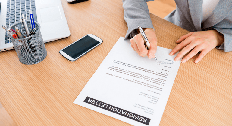 Woman signing a resignation letter 