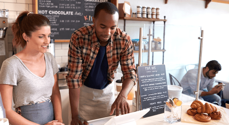 2 cafe workers using a laptop