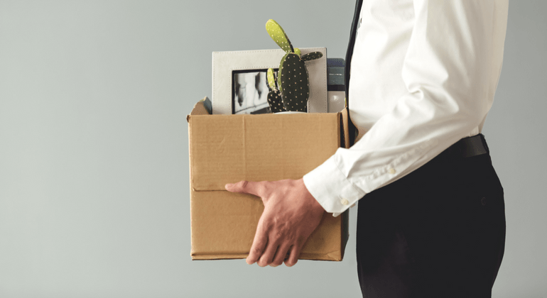 Man holding box of his office belongs 