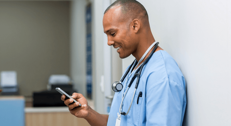 Male healthcare worker scrolling on a cell phone