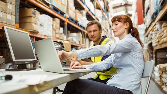 Female manager training male employee in a factory setting 