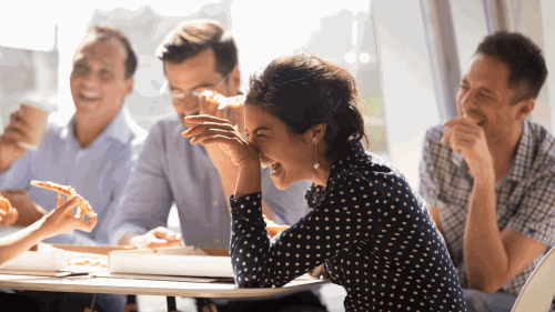 woman and coworkers eating pizza and laughing