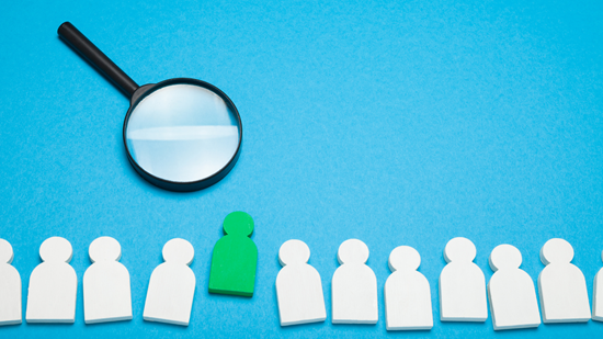 Magnifying glass looking at white paper cut outs