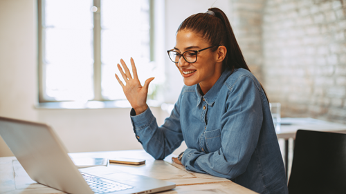 woman waving at laptop